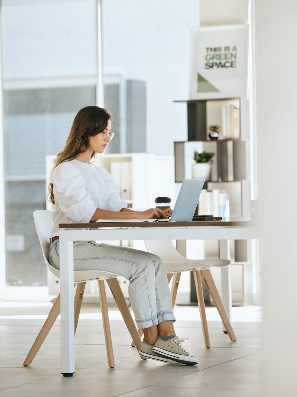 woman-working-and-laptop-at-digital-marketing-company-eco-startup-and-work-with-technology-at-white desk against window